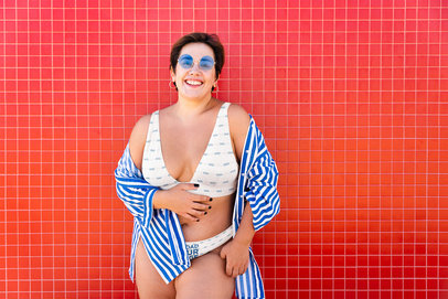 Bikini Mockup of a Joyful Woman Posing Against a Red Wall