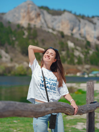 T-Shirt Mockup of a Woman with Straight Hair Posing in Front of a Mountain
