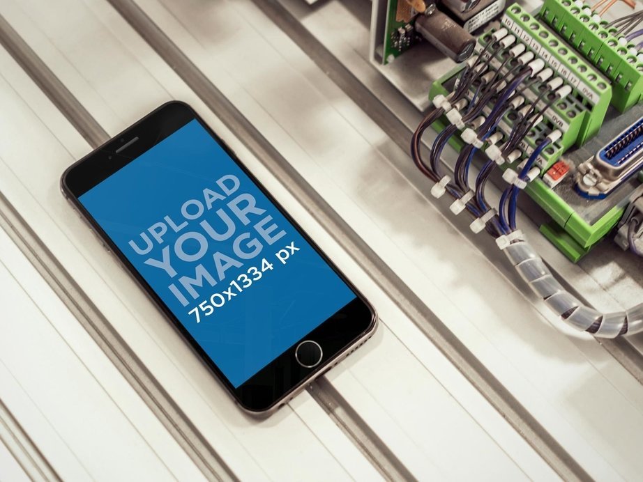 Mockup of Black iPhone 6 With Cables at Industrial Workplace