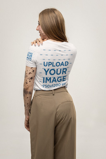 Back-View Bella Canvas Tee Mockup of a Woman Standing in a Studio