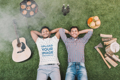 Heathered T-Shirt Mockup Featuring a Smiling Bearded Man Lying on the Grass for Canada Day With a Friend