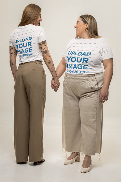 Bella Canvas T-Shirt Mockup Featuring Two Women Smiling and Holding Hands in a Studio