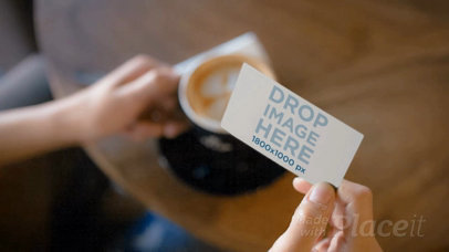 Video of a Business Card Being Held by a Person while Having a Coffee