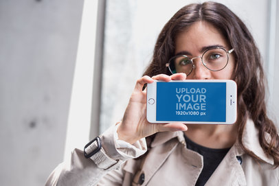 Mockup of a Girl Holding a Rose Gold iPhone 7 Plus in Landscape Position Against her Mouth a21277