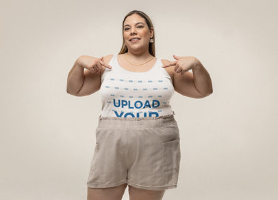 Mockup of a Woman Pointing at Her Plus Sized Bella Canvas Tank Top
