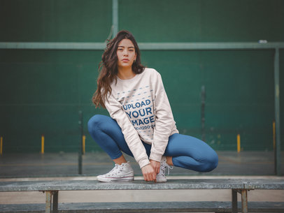 Crewneck Sweatshirt Mockup of a Woman Crouching on a Steel Beam a19049