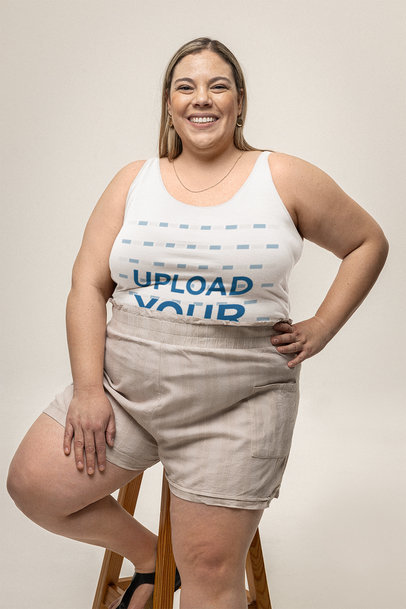 Tank Top Mockup Featuring a Smiling Woman Sitting on a Stool in a Studio