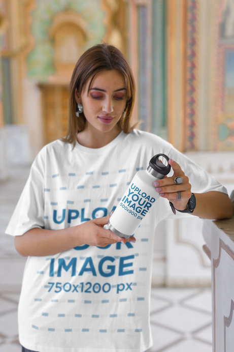 Oversized T-Shirt Mockup of a Woman Holding a Travel Mug