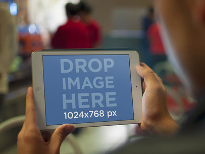 iPad Mini Mockup Featuring a Man Holding His White iPad in Landscape
