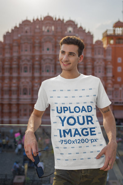 Gildan T-Shirt Mockup Featuring a Happy Man Posing in a Balcony Against a Historical Place