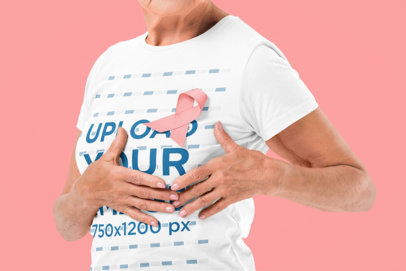 T-Shirt Mockup of an Elderly Woman Proudly Wearing a Pink Ribbon for Cancer Awareness
