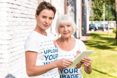 T-Shirt Mockup Featuring Two Women Wearing Pink Ribbons for Breast Cancer Awareness