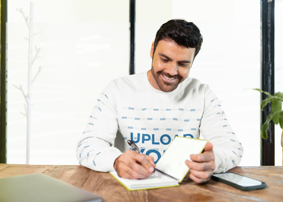Gildan Sweatshirt Mockup Featuring a Happy Bearded Man Writing in a Notebook
