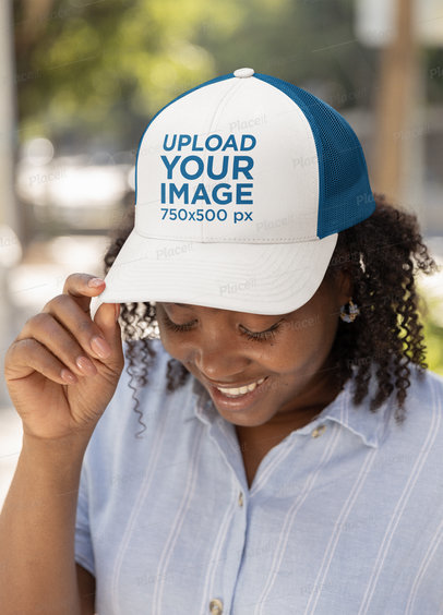 Mockup of a Happy Woman with Curly Hair Wearing a Trucker Hat m34835