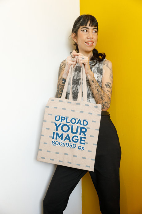Mockup Featuring a Tattooed Woman Holding a Sublimated Tote Bag