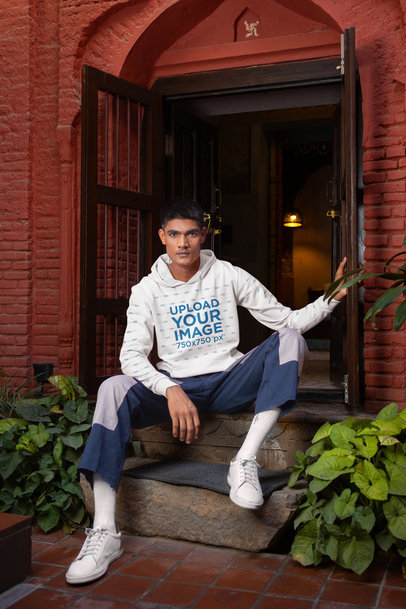 Gildan Hoodie Mockup of a Man Posing at an Ancient Building's Entrance