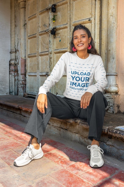 Bella Canvas Long-Sleeve Tee Mockup of a Smiling Woman Sitting in an Old Building