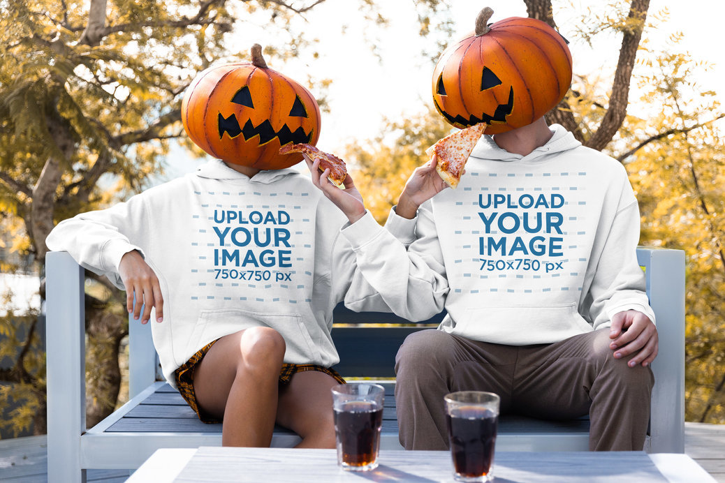 Hoodie Mockup Featuring a Man and a Woman With a Pumpkin Mask Eating Pizza