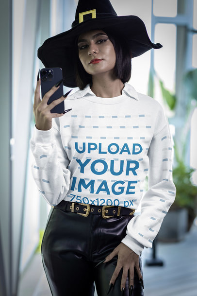 Halloween-Themed Sweatshirt Mockup of a Woman with a Witch Hat Taking a Selfie