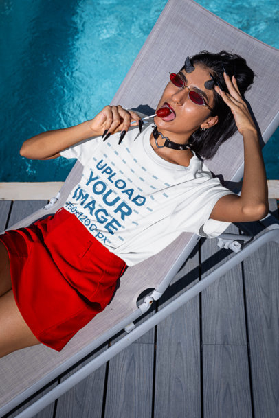 Funny Halloween-Themed Tee Mockup of a Woman with Devil Horns Lying by a Pool m35484