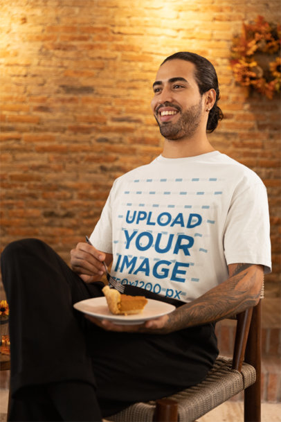 Stanley Stella T-Shirt Mockup of a Man with an Arm Tattoo Eating a Slice of Pumpkin Pie
