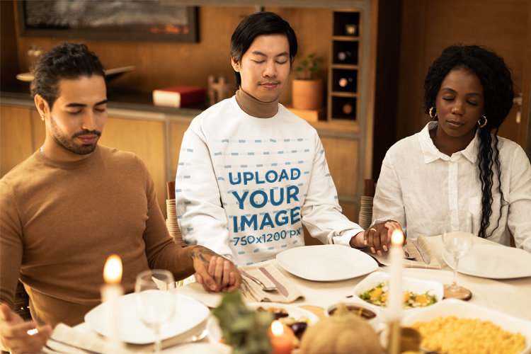 Gildan Sweatshirt Mockup Featuring a Man Praying in a Thanksgiving Dinner With Friends