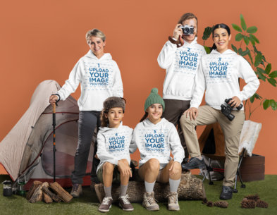 Gildan Hoodie Mockup Featuring a Smiling Family Posing in a Camping-Themed Setting