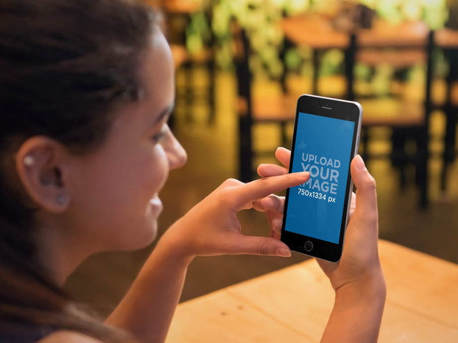 Placeit - Mockup of a Woman Using an iPhone 6 At a Restaurant