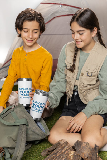 Mockup of Two Siblings Holding Sublimated Travel Mugs at a Camping Site