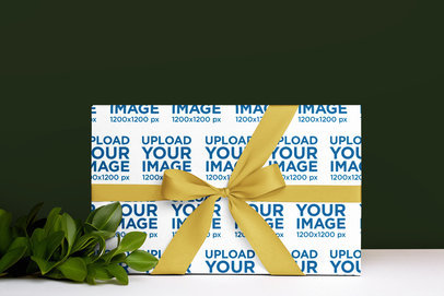 Wrapping Paper Mockup Featuring a Gift and Some Leaves