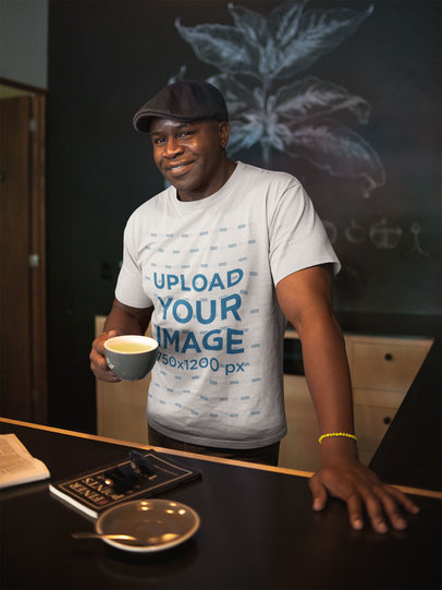Mockup of a Man Wearing a T-Shirt and a Beret Having a Coffee