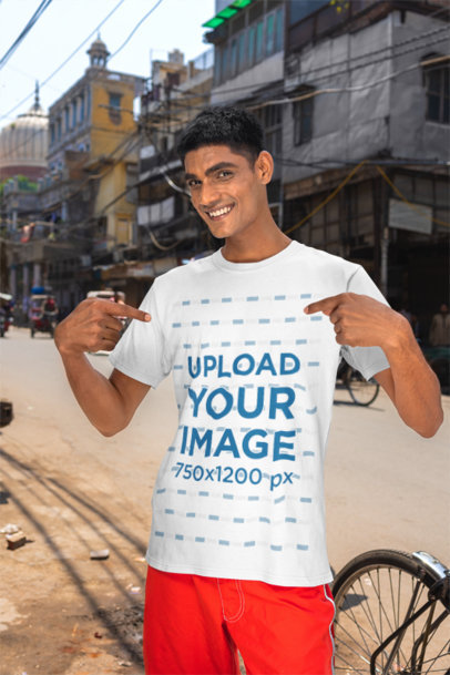 Mockup of a Smiling Man Pointing at His New Gildan T-Shirt on The Street
