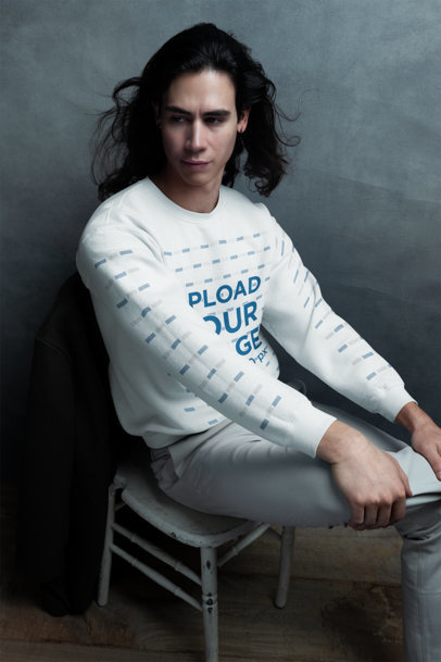Gildan Sweatshirt Mockup of a Serious Man Sitting on a Chair in a Studio