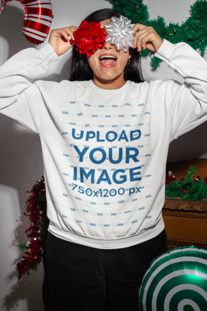 Gildan Sweatshirt Mockup Featuring a Cheerful Woman Celebrating Christmas With Ribbons on Her Eyes
