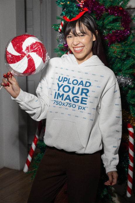 Christmas-Themed Gildan Hoodie Mockup of a Happy Woman Holding a Giant Lollipop