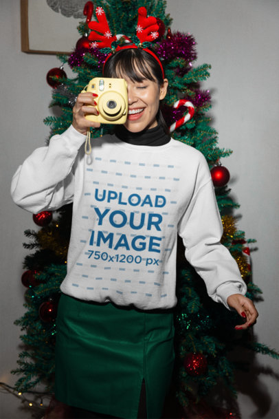 Xmas-Themed Gildan Sweatshirt Mockup of a Woman Taking a Picture with an Instant Camera