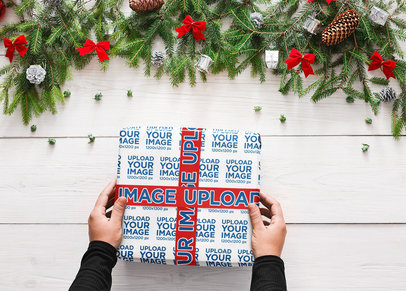 Mockup of a Person Holding a Christmas Present Covered in Wrapping Paper