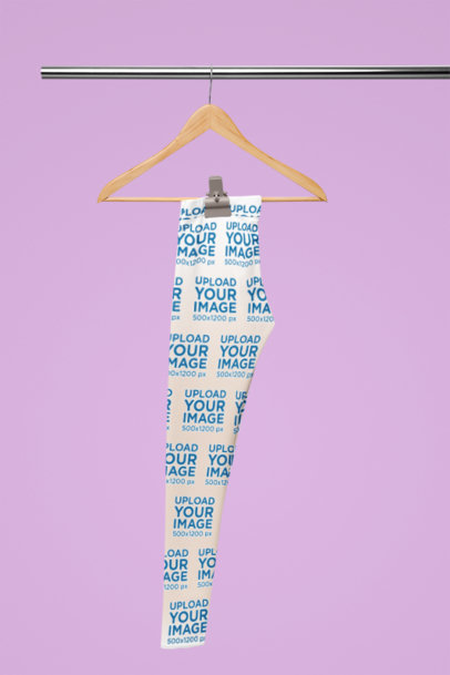 Mockup Featuring a Pair of Sublimated Leggings Placed on a Wooden Hanger