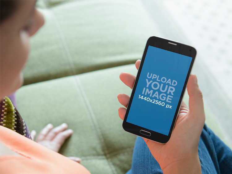 Mockup of a Woman Using an Android While Sitting on a Couch
