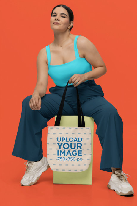 Mockup of a Smiling Woman Holding a Sublimated Tote Bag in a Studio