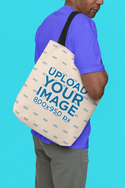 Mockup of a Man Carrying a Sublimated Tote Bag on His Shoulder