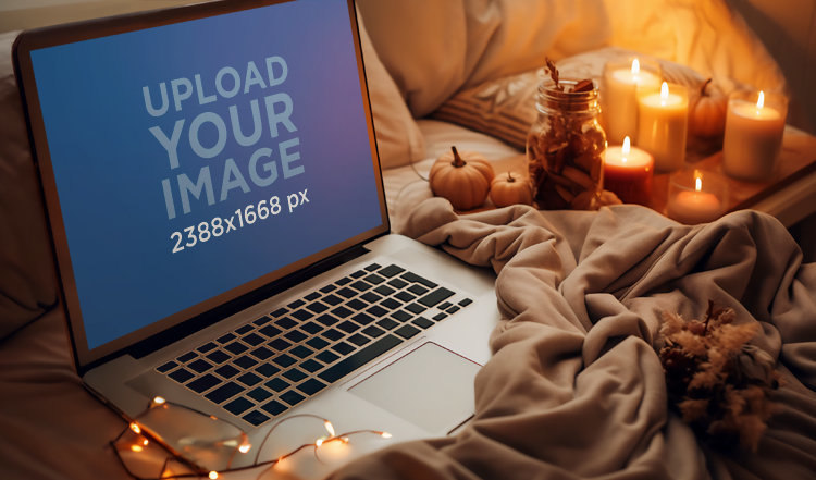 Autumn-Season Mockup of a MacBook Placed in a Cozy Setting with Candles 