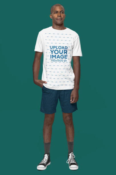 Mockup of a Man Standing in a Studio Wearing a Next Level T-Shirt