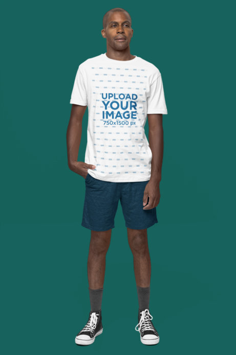 Mockup of a Man Standing in a Studio Wearing a Next Level T-Shirt