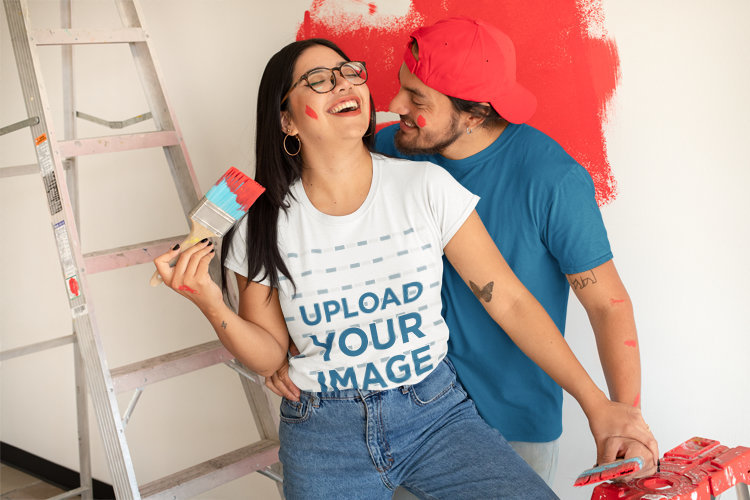 Round-Neck Tee Mockup of a Couple Painting a Wall and Having Fun Together