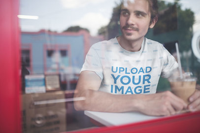 Mockup of a Happy Man Wearing a Sublimated T-Shirt while Having a Frappuccino a20144
