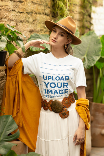Bella Canvas T-Shirt Mockup of a Woman in a Boho-Inspired Outfit Posing by Some Plants