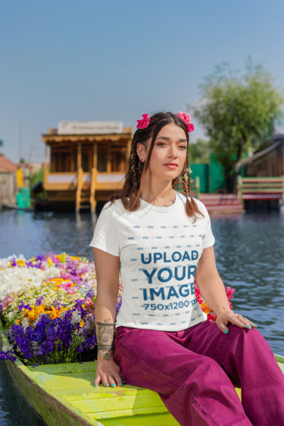 Gildan T-Shirt Mockup Featuring a Woman Sitting on a Flower-Decorated Raft at a Lake m35557
