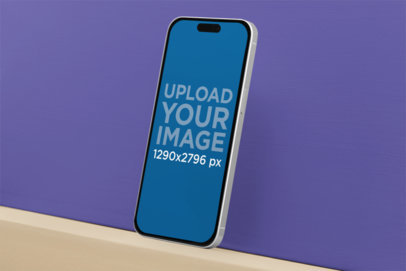 Mockup of an iPhone 15 Pro Max Leaning Against a Customizable Surface m36713