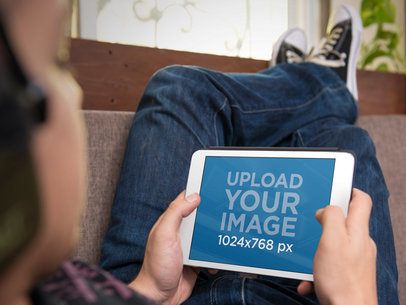 iPad Mockup Template Featuring a Teenager Using White iPad on the Couch